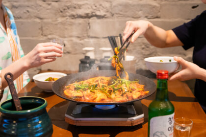 タッカンマリ食べ放題の「晴レ時々タッカンマリ食堂」に山盛りのセリを豪快に崩して味わう新感覚の鉄板鍋”旨辛タッコギ鉄板鍋”が夏の看板メニューとして新登場!7月24日から。